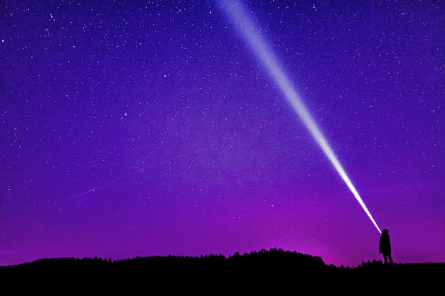 Foto silueta de pessoa sob o céu azul e roxo foto