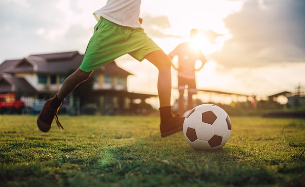 Silueta deporte de acción al aire libre de un grupo de niños jugando fútbol soccer.