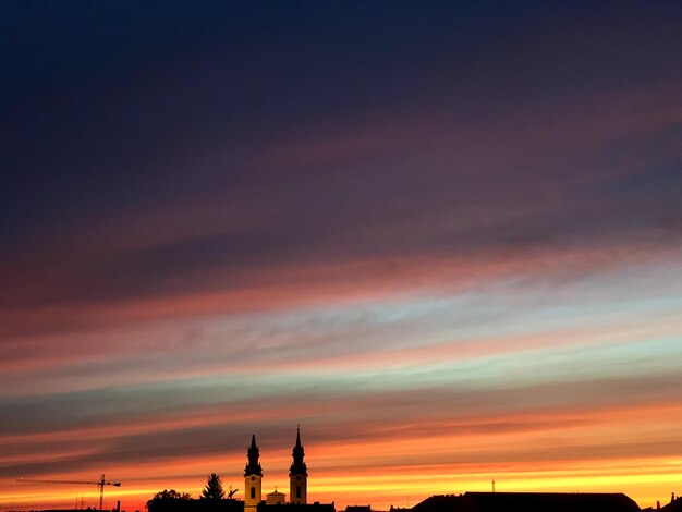 Silueta do edifício contra o céu dramático durante o pôr do sol