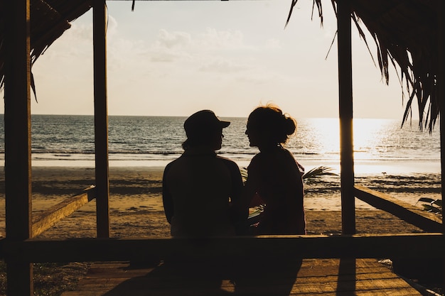 Silueta dos amantes sentado en la cabaña