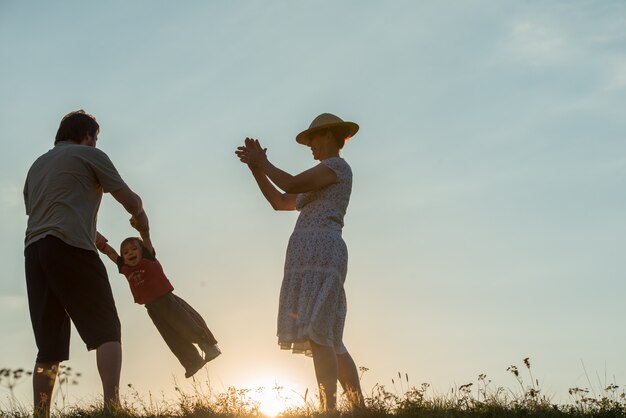 silueta de familia feliz disfrutando en el acantilado