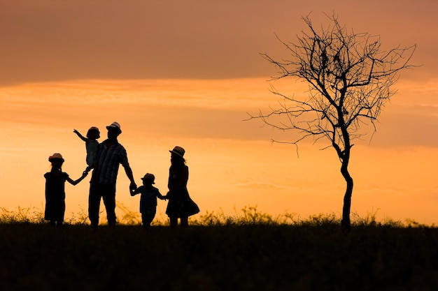 Una silueta de familia feliz en la naturaleza en el fondo del parque