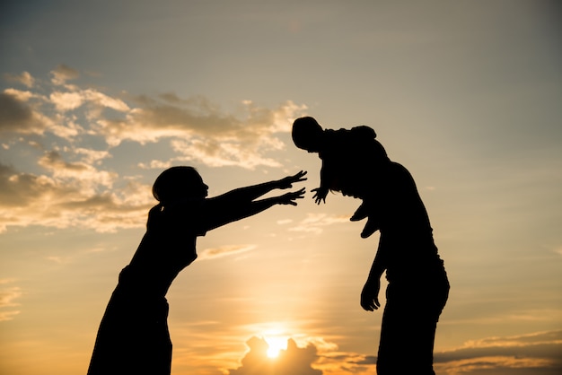 Silueta de familia feliz padres divirtiéndose