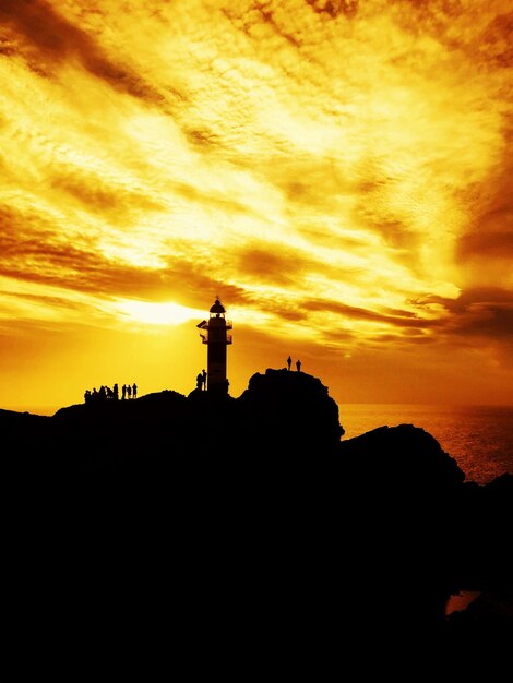 Foto la silueta del faro contra el cielo durante la puesta de sol