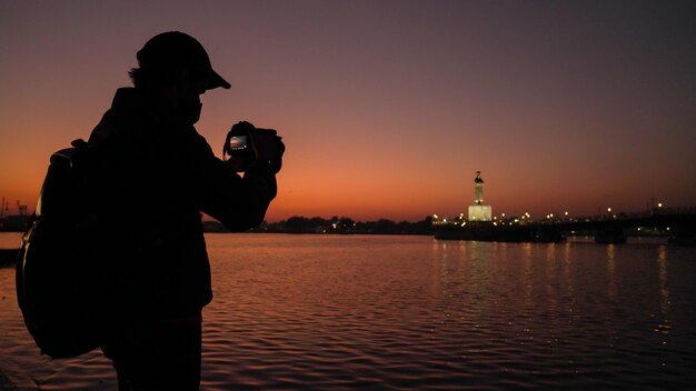 Silueta de un fotógrafo capturando la puesta de sol en la fotografía de fotógrafo de viajes de India