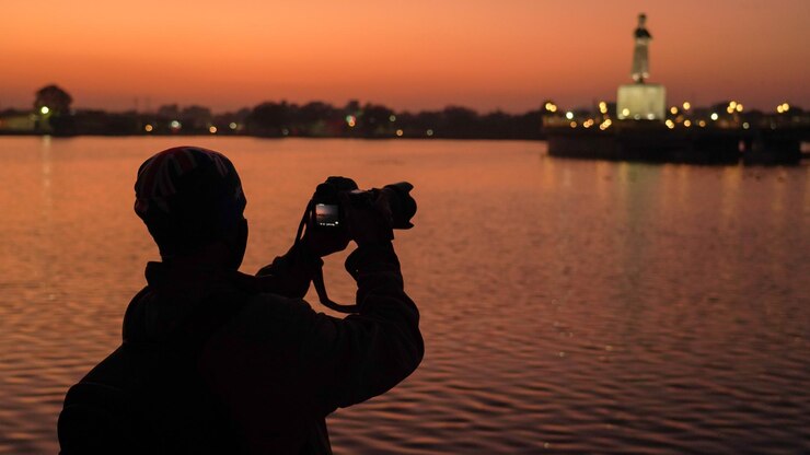 Silueta de un fotógrafo capturando la puesta de sol en India fotógrafo de viajes disparando a la hermosa