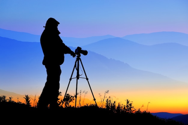 Silueta de un fotógrafo de paisajes en el crepúsculo