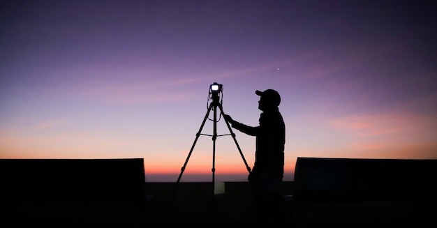 Foto silueta, de, un, fotógrafo, con, trípode, joven, indio, hombre, toma, foto, con, el suyo, cámara