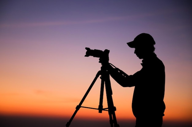 silueta, de, un, fotógrafo, con, trípode, joven, indio, hombre, toma, foto, con, el suyo, cámara