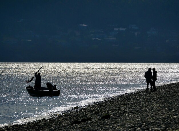 La silueta de la gente por el mar