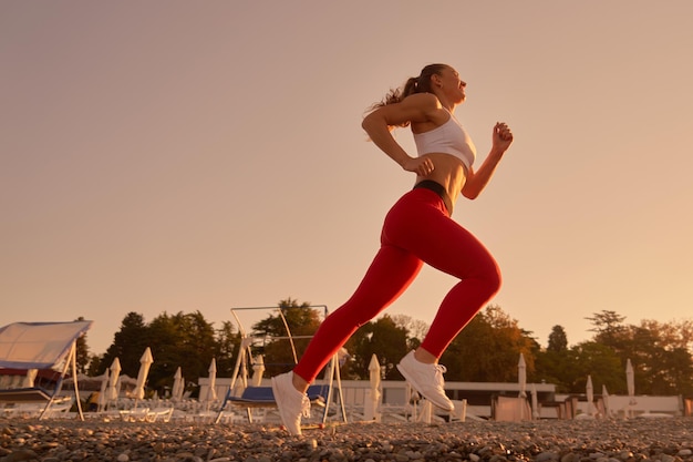 Silueta de hermosa mujer deportiva en ropa deportiva para correr en el amanecer de la mañana