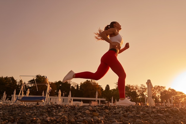 Silueta de hermosa mujer deportiva en ropa deportiva para correr en el amanecer de la mañana