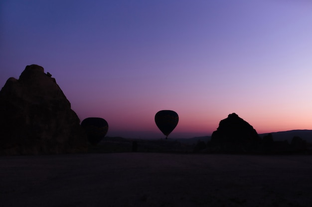 Silueta de hermosos globos aerostáticos al amanecer en capadocia