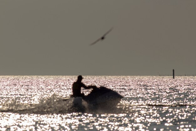 Foto silueta de hombre borroso en jetski