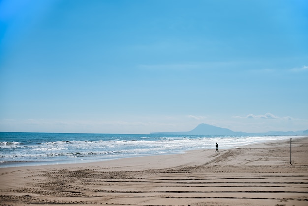 Silueta de hombre caminando hacia el mar