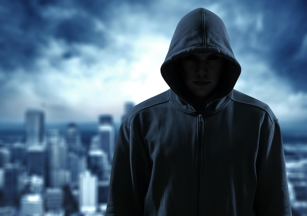 Silueta de hombre en el capó o hooligan sobre fondo de hormigón oscuro con espacio de copia