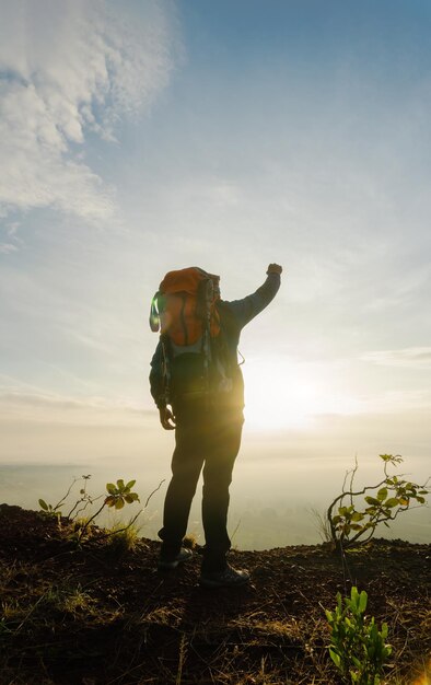 Silueta de un hombre en la cumbre Majestico amanecer en la montaña