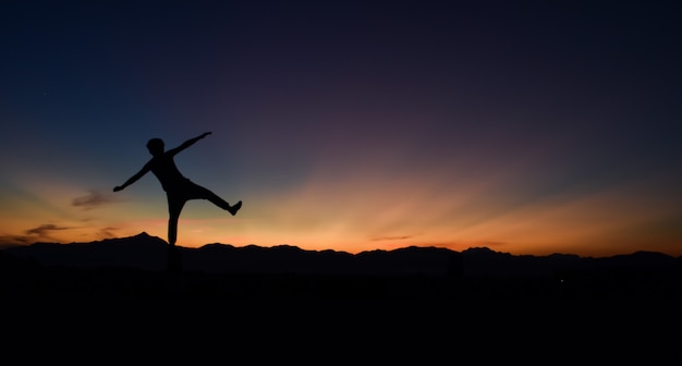 Silueta de hombre haciendo caminar al atardecer