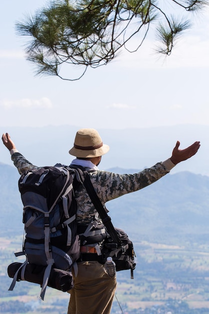 Silueta de un hombre con las manos en alto en la cima de la montaña concepto de éxito