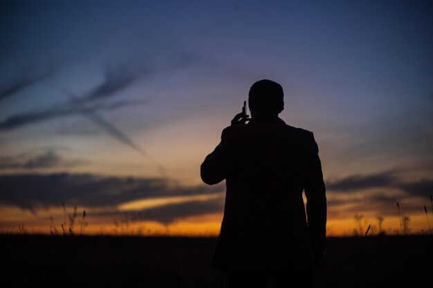 Silueta de un hombre de negocios al amanecer en la naturaleza El concepto de negociaciones comerciales desarrollo éxito nuevas oportunidades