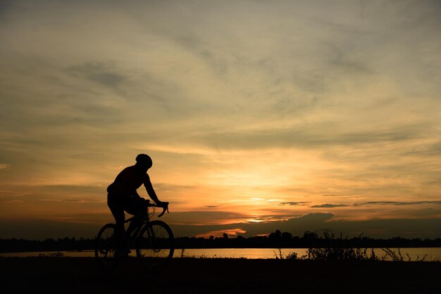 silueta, de, hombre, paseo, bicicleta, en, ocaso