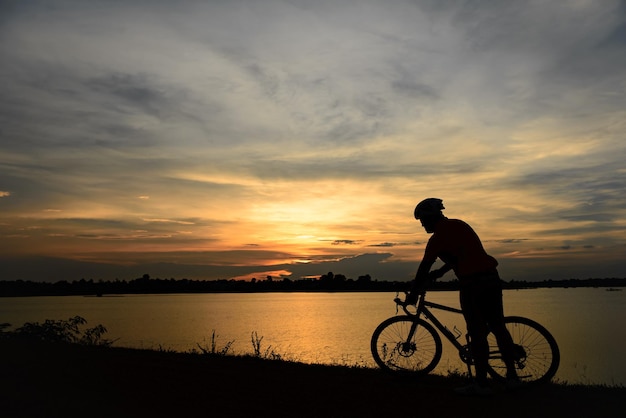 silueta, de, hombre, paseo, bicicleta, en, ocaso