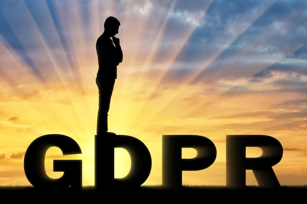 Silueta de hombre pensativo de pie sobre la palabra GDPR. Imagen conceptual sobre la ley GDPR