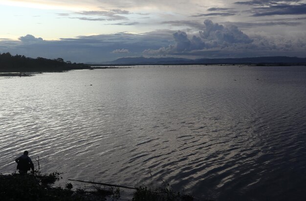 Silueta de un hombre pescando en la tarde.