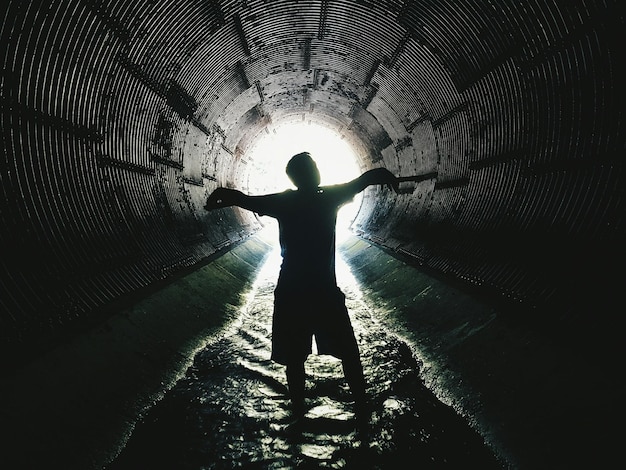Silueta de un hombre de pie en un túnel