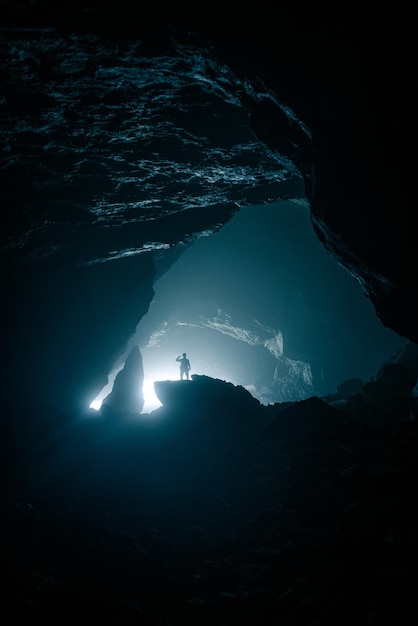 Foto silueta de un hombre en una roca en una cueva