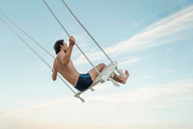 Silueta de hombre solitario balanceándose al atardecer Hombre balanceándose y volando en el cielo Vacaciones de verano