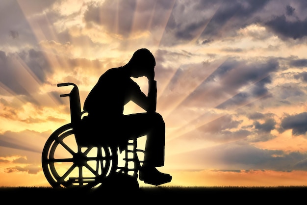 Silueta de hombre triste triste en silla de ruedas en depresión. El concepto de personas con discapacidad que experimentan dipresión.