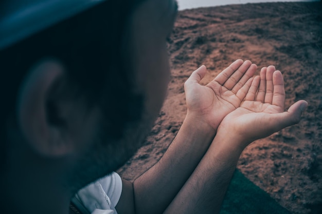 Silueta Joven musulmán asiático rezando en el concepto del festival sunsetRamadan