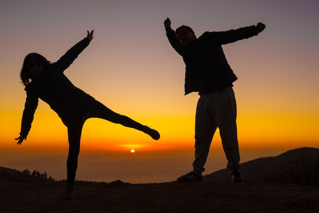 Silueta de jóvenes al atardecer en la cima del Teide en la isla de Tenerife