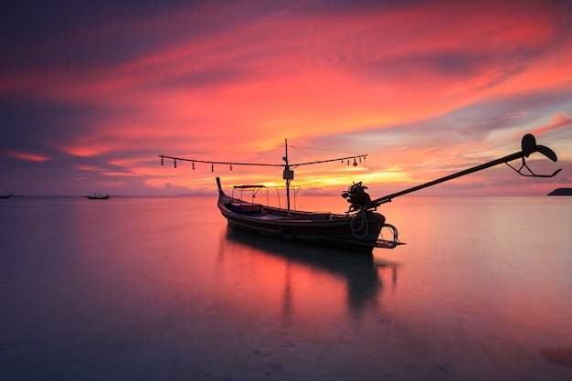 Silueta longtail boat tradicional y hermoso cielo rojo