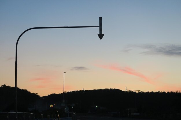 Silueta de la luz de la calle contra el cielo al atardecer