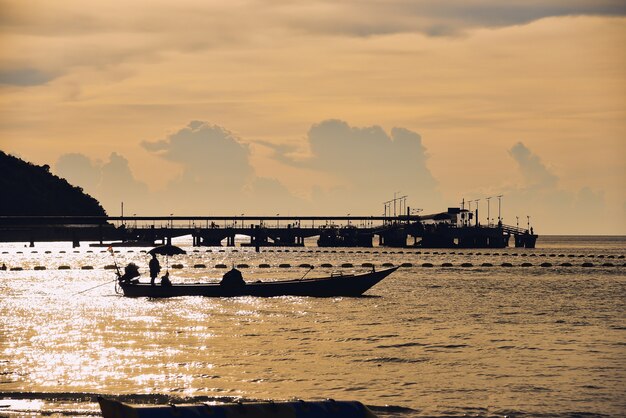 Silueta del mar y barco en la puesta de sol