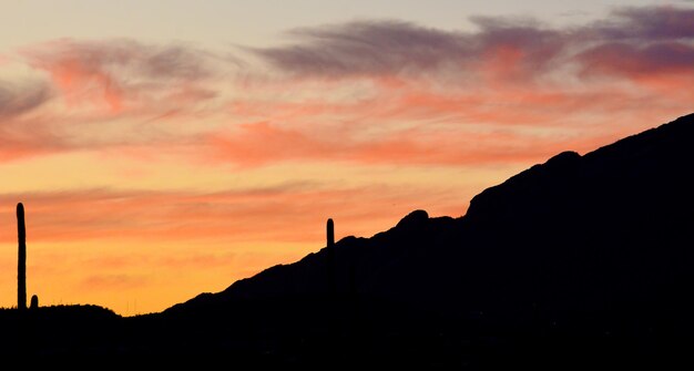 Foto silueta de la montaña contra el cielo dramático durante la puesta de sol