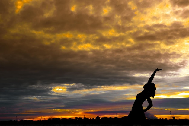 silueta, de, mujer asiática, juego, yoga, en, ocaso