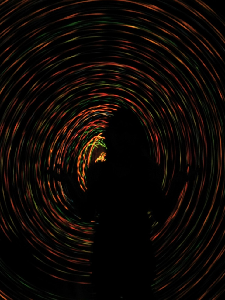 Foto la silueta de la mujer contra el movimiento borroso de las luces de cuerda