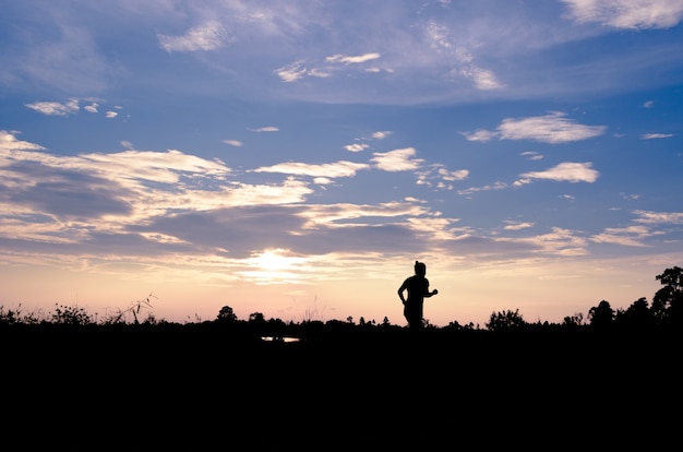 Silueta de una mujer para correr al ejercicio al atardecer.