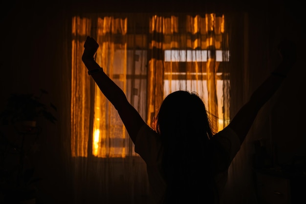 Silueta de mujer delante de la ventana. amanecer en la ventana. Despierta por la mañana