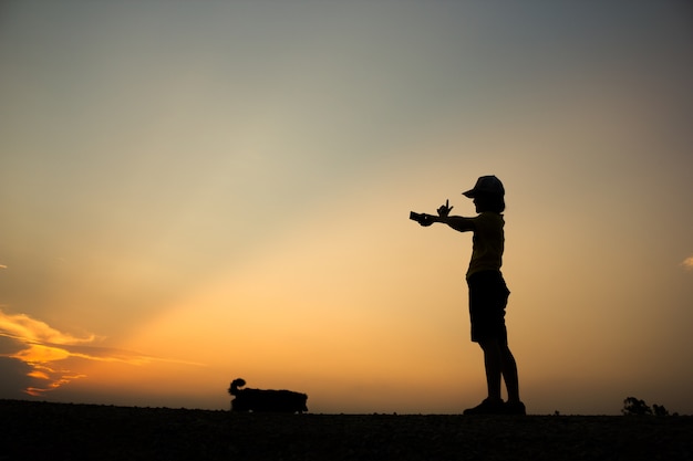 Silueta de la mujer es tomar fotos hermosa puesta de sol.