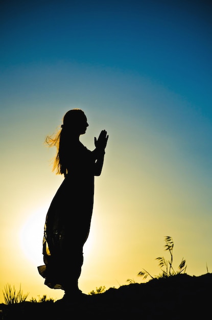 Silueta de mujer frente a una puesta de sol