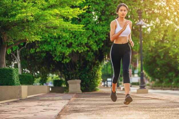 Silueta de mujer joven corriendo corriendo en la carretera Fit runner fitness runner entrenamiento al aire libre