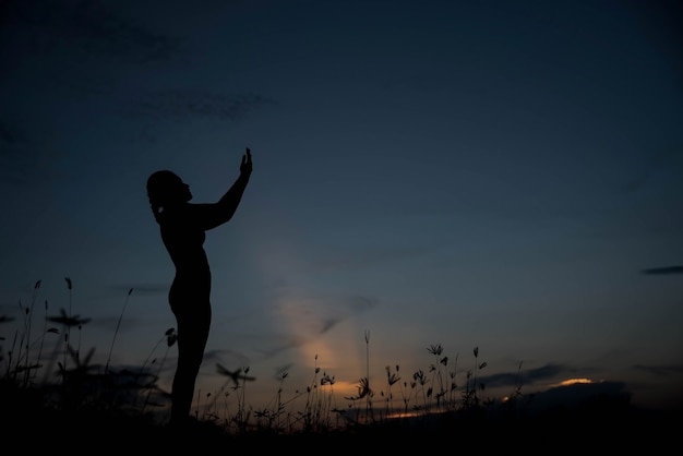 Silueta, mujer joven, sola, con, dios, en, ocaso