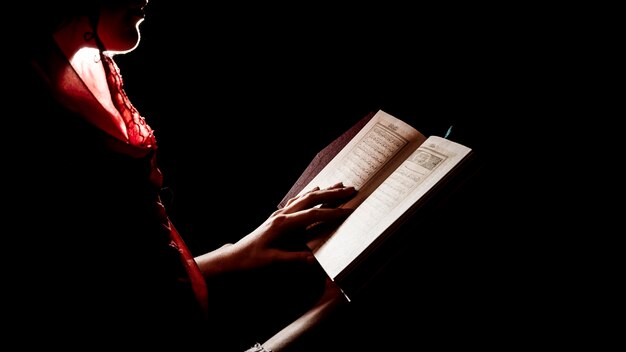 Foto silueta de mujer leyendo en corán
