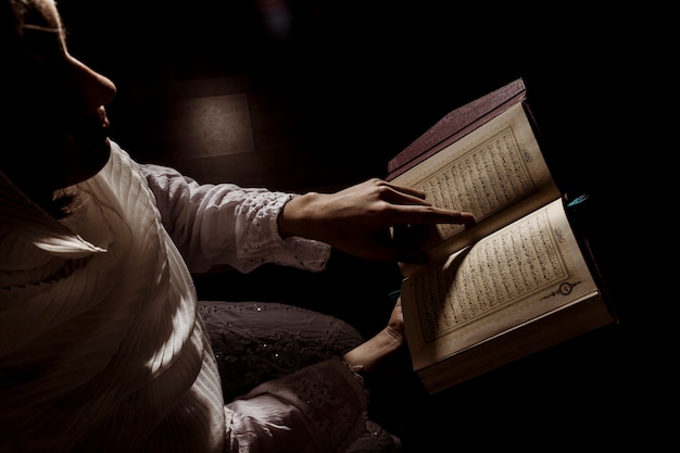 Foto silueta de mujer leyendo en corán