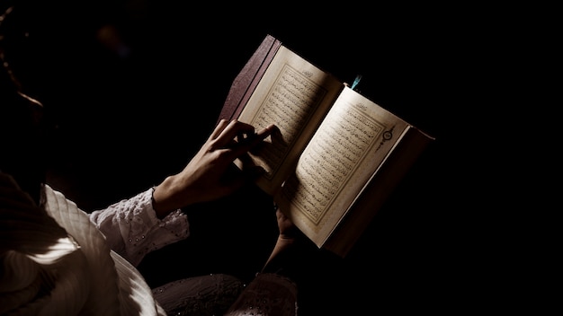 Foto silueta de mujer leyendo en corán