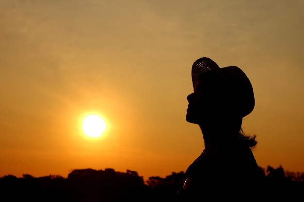 Silueta de una mujer mirando hacia el cielo del amanecer